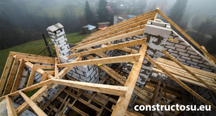 Șantier la acoperișul unei construcții noi, faza de ridicare a căpriorilor, a șarpantei și a coamei.