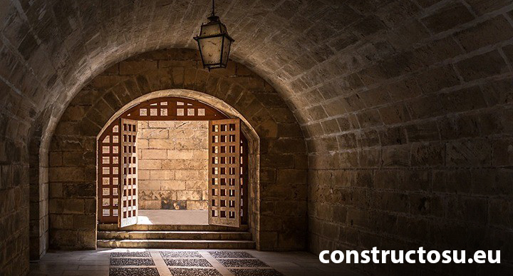 Intrare în beci, construită din piatră cu porți de lemn.