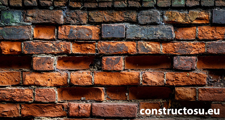 Zid din cărămidă plină cu goluri și mortar deteriorat, bucăți lipsă mușchi spart